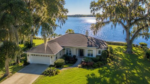 An established lakefront home with mature oak trees and Spanish moss near Lake Ariana in Auburndale Florida